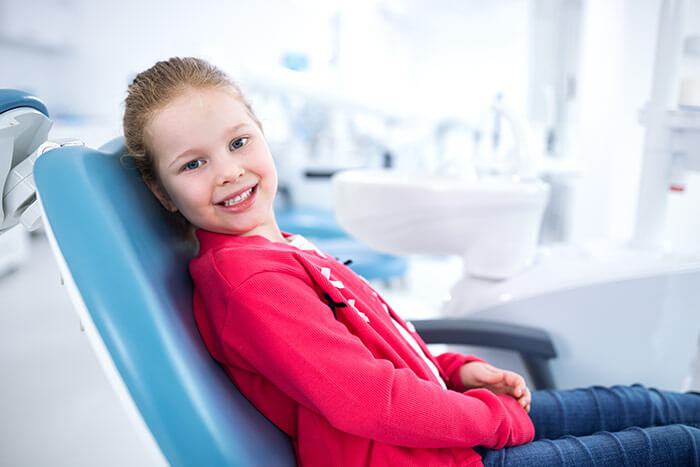 young girl smiling in dentist chair